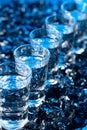 Damp glasses of vodka with ice on a black reflective background Royalty Free Stock Photo