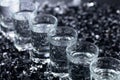Damp glasses of vodka with ice on a black reflective background Royalty Free Stock Photo