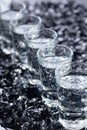 Damp glasses of vodka with ice on a black reflective background Royalty Free Stock Photo