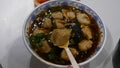 Damplings soup in bowl, woman hand with spoon stir hot food