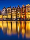 Damrak, Amsterdam, Netherlands. View of houses during sunset. The famous Dutch canals. A cityscape in the evening. Royalty Free Stock Photo