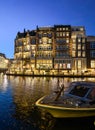 Damrak narrow houses at night in Amsterdam center, Netherlands