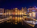 Damrak narrow houses at night in Amsterdam center, Netherlands