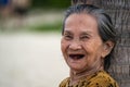 Vietnamese old woman relax on the sand beach near sea on the city Danang, Vietnam, close up