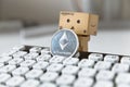 Danbo the box man posing with etherum next to computer keyboard