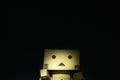 Danbo is a robot doll on an isolated black background. Alone in the darkness.