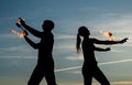 Dance all night. Fire dancers on evening sky. Couple of dancers spin flaming poi. Fire performance. Party or festival Royalty Free Stock Photo