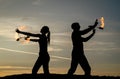 Dance all night. Fire dancers on evening sky. Couple of dancers spin flaming poi. Royalty Free Stock Photo