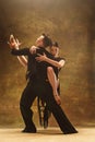 Dance ballroom couple in gold dress dancing on studio background. Royalty Free Stock Photo