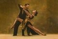 Dance ballroom couple in gold dress dancing on studio background. Royalty Free Stock Photo