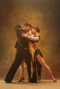 Dance ballroom couple in gold dress dancing on studio background. Royalty Free Stock Photo