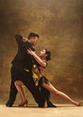 Dance ballroom couple in gold dress dancing on studio background. Royalty Free Stock Photo