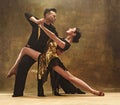 Dance ballroom couple in gold dress dancing on studio background. Royalty Free Stock Photo