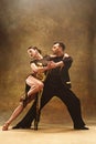 Dance ballroom couple in gold dress dancing on studio background. Royalty Free Stock Photo