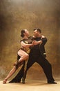 Dance ballroom couple in gold dress dancing on studio background. Royalty Free Stock Photo