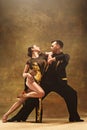 Dance ballroom couple in gold dress dancing on studio background. Royalty Free Stock Photo