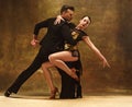 Dance ballroom couple in gold dress dancing on studio background. Royalty Free Stock Photo