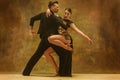 Dance ballroom couple in gold dress dancing on studio background. Royalty Free Stock Photo