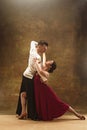 Dance ballroom couple in red dress dancing on studio background. Royalty Free Stock Photo