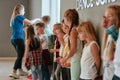 Dance class. Group of cute and positive children with young female teacher standing at the dance studio. Choreography Royalty Free Stock Photo