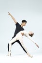 Dance Couple of Asian Young Man and Caucasian Woman Performing As Ballet Dancers Over Grey in Studio During Suppots As Classical Royalty Free Stock Photo