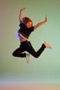 Dance, fun, joy. Happy little girl, kid in casual clothes jumping high isolated over light background. Kids fashion Royalty Free Stock Photo