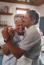 Dance the grey away. a happy mature couple dancing together while cooking in the kitchen at home.