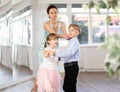 Teacher rearrange dancers pose during pair ballroom dancing lesson.