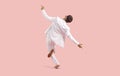 Back view of funny happy young man in white suit dancing isolated on pink background