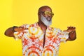 Dance like no one is watching. a funky and stylish senior man dancing in studio against a yellow background. Royalty Free Stock Photo