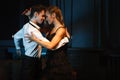 Dance and love concept. Young couple in elegant evening dresses posing in the room filled with dramatic light. Two Royalty Free Stock Photo