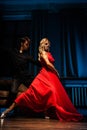 Dance and love concept. Young couple in elegant evening dresses posing in the room filled with dramatic light. Two Royalty Free Stock Photo