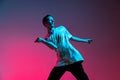 Cropped horizontal portrait of young male hip-hop dancer practising isolated over gradient pink purple background in Royalty Free Stock Photo