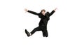 Excited young man in black business suit dancing and listening music isolated on white background. Art, motion, action Royalty Free Stock Photo