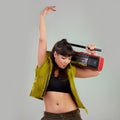 Dance, trendy and woman with a radio for music isolated on a grey studio background. Party, fashion and dancing girl