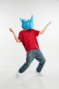 Dance. Young man in red t-shirt with cardboard animal mask on his head isolated on white background. Concept of art Royalty Free Stock Photo