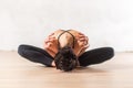 Dancer doing advanced butterfly stretch exercise sitting leaning forward holding shoulders. Young flexible woman i