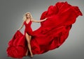 Dancer Girl in Red Dress flying on Wind. Fashion Model in Long Luxury Silk waving Gown. Sexy Blond Woman with Wavy Hairstyle