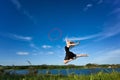 Jymnast with hoop jumping against blue sky Royalty Free Stock Photo