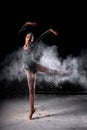 flexible Dancer posing dancing gracefully in studio with cloud of dust, flour. Royalty Free Stock Photo