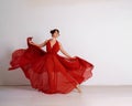 Dancer in a red flying dress. Woman ballerina dancing on a white studio background Royalty Free Stock Photo