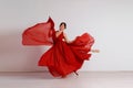 Dancer in a red flying dress. Woman ballerina dancing on a white studio background Royalty Free Stock Photo