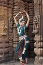 Odissi Dancer wears traditional costume and performs Odissi dance at Mukteshvara Temple,Bhubaneswar, Odisha, India