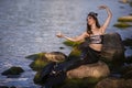 Dancing Asian Mermaid Posing With Seashell At Sea Shore on Rocks While Wearing Seashell Decorated Crown and Black Shiny Tail On