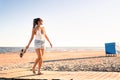 Dancing on the beach at sunset. Playful positive woman walking at sea shore. Summertime freedom, wellness and happy lifestyle.