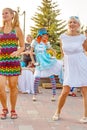 Dancing beautiful and elegant stylish girls participating in the carnival costumed women`s bike ride in the summer evening Royalty Free Stock Photo