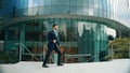 Dancing business man walking and hold bag while dancing at park. Exultant. Royalty Free Stock Photo