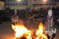 Dancing devotees with fire and masks in the procession of the vigen del carmen in the streets at night