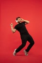 Full length portrait of young successfull high jumping man gesturing  on red studio background Royalty Free Stock Photo