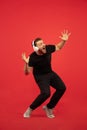 Full length portrait of young successfull high jumping man gesturing isolated on red studio background Royalty Free Stock Photo